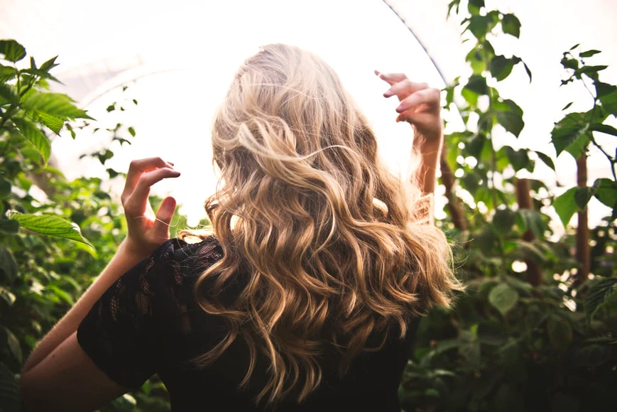 a woman with loose curly blonde hair